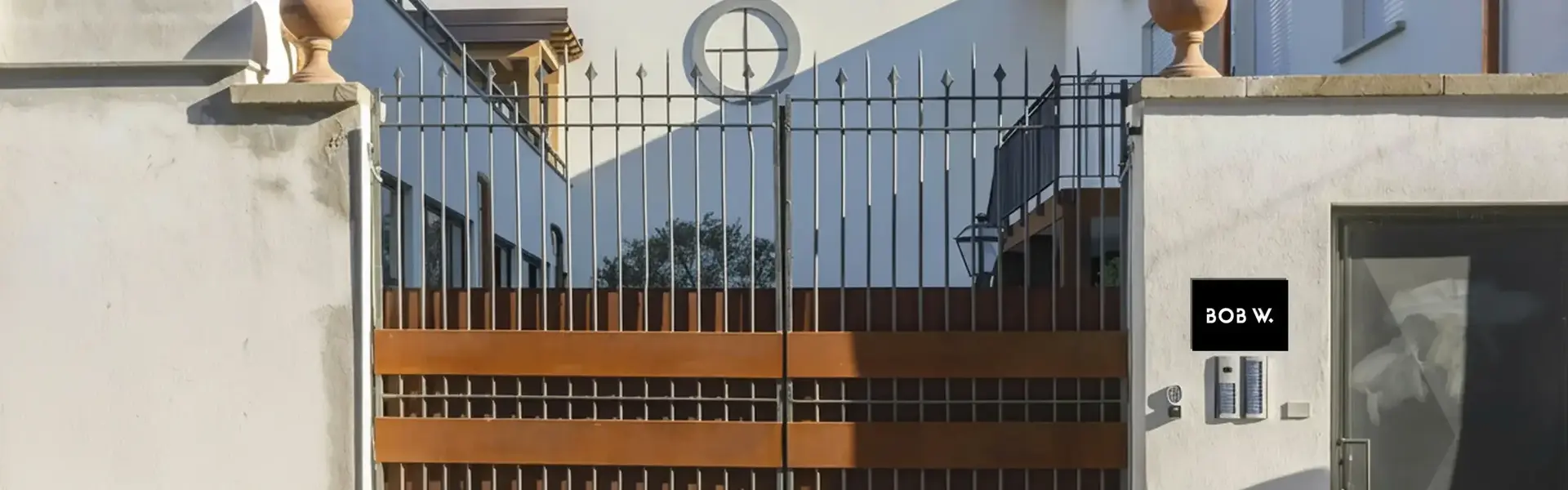 a gated driveway with a house behind it