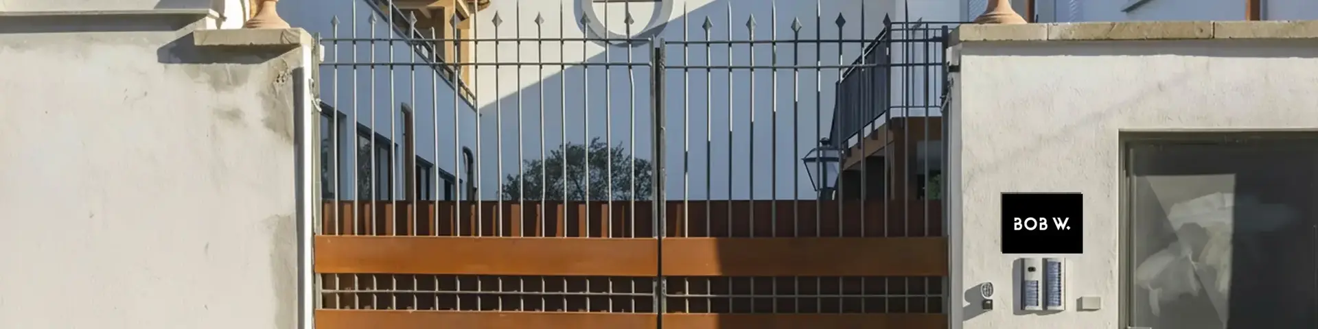 a gated driveway with a house behind it