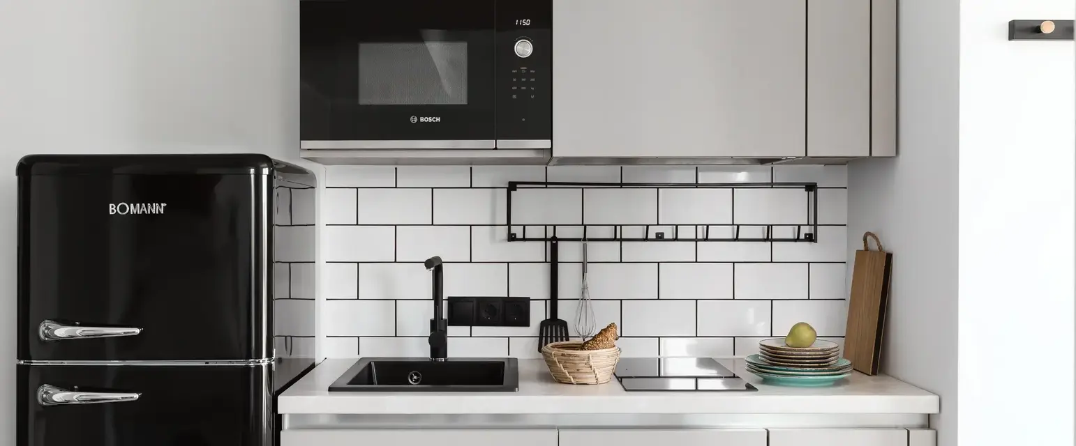 a kitchen with white cabinets and black appliances