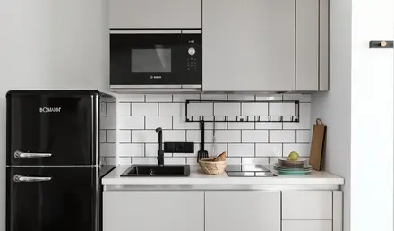 a kitchen with white cabinets and black appliances