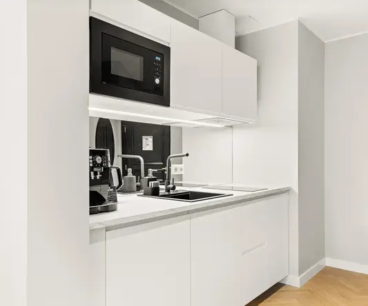 a kitchen with white cabinets and black appliances