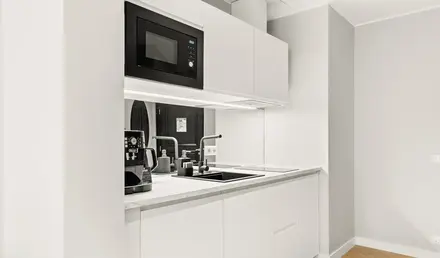 a kitchen with white cabinets and black appliances