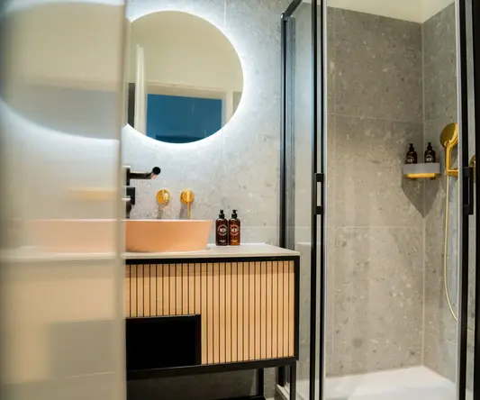 a bathroom with a round mirror and a sink