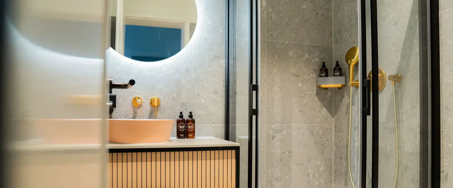 a bathroom with a round mirror and a sink