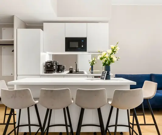 a kitchen with white cabinets and white countertops