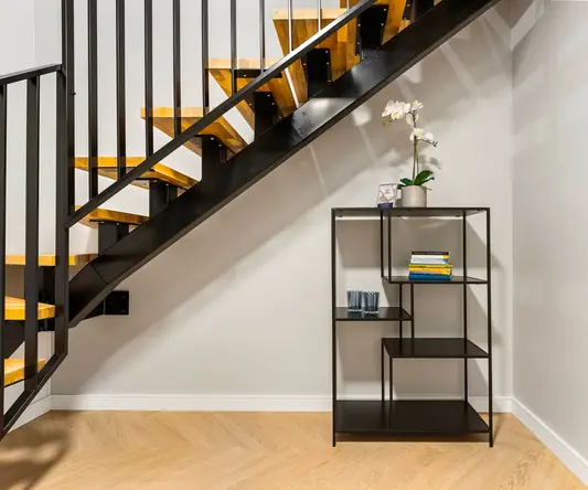 a black shelf next to a staircase