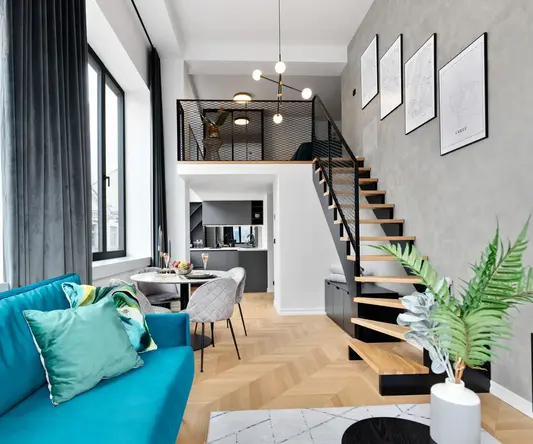 a living room with a staircase and a blue couch