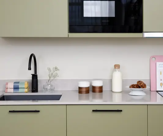 a kitchen counter with a microwave and a black microwave