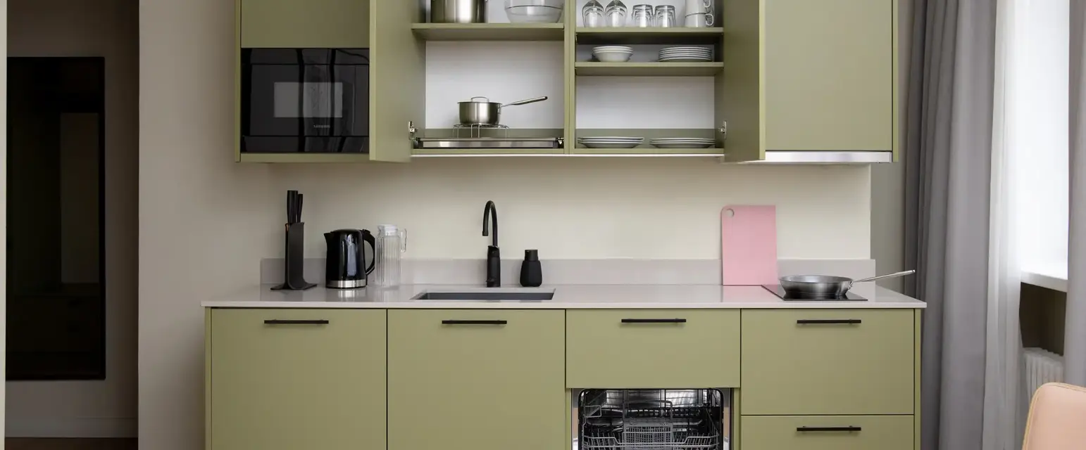 a kitchen with green cabinets and a stove