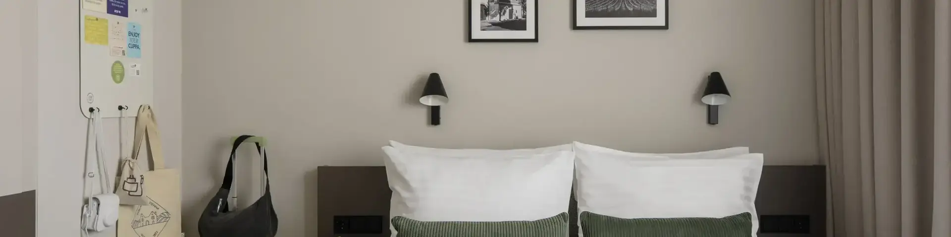 a bed with pillows and a suitcase on the side