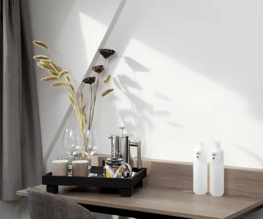 a table with a tray of wine glasses and a bottle of liquid on it