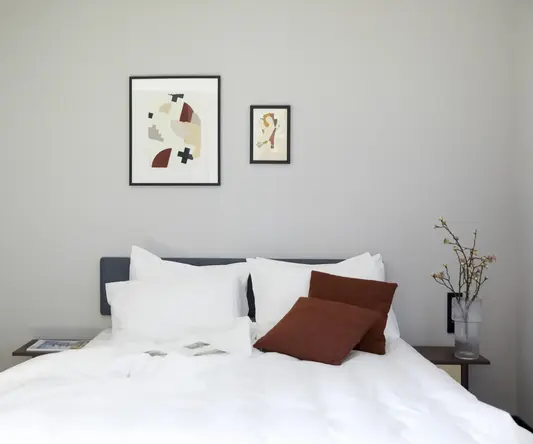 a bed with white sheets and pillows