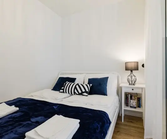 a bed with blue blanket and pillows