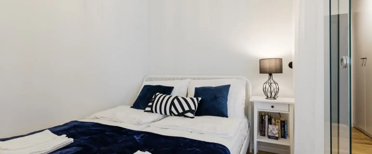 a bed with blue blanket and pillows