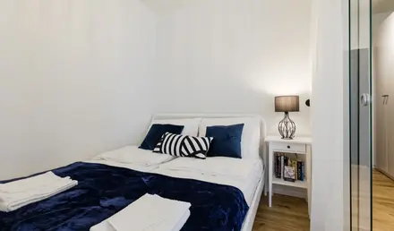 a bed with blue blanket and pillows