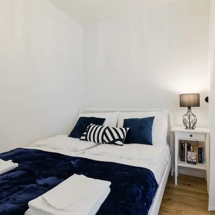 a bed with blue blanket and pillows