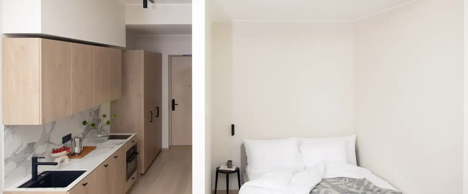 a small room with a bed and kitchen