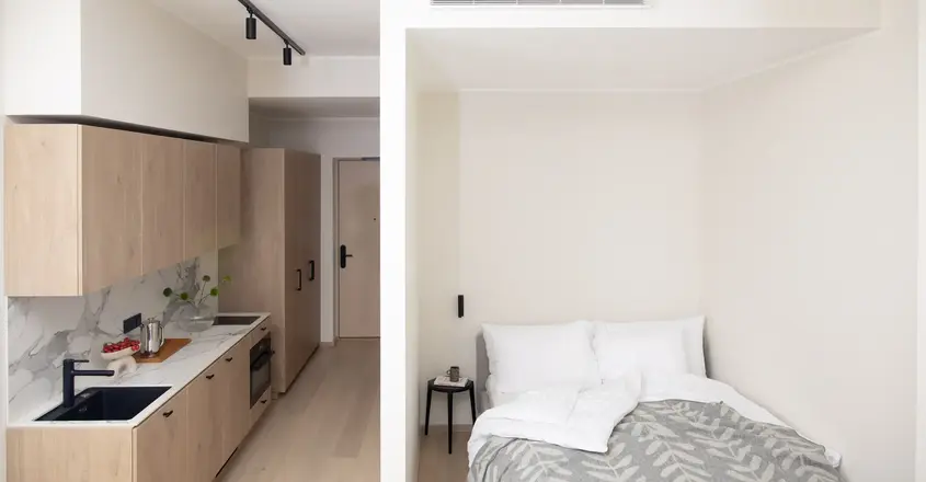 a small room with a bed and kitchen