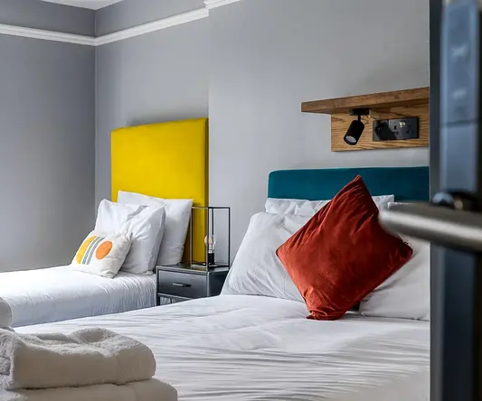 a bed with white sheets and pillows