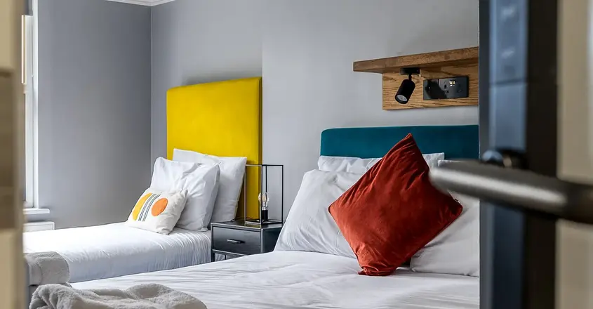 a bed with white sheets and pillows