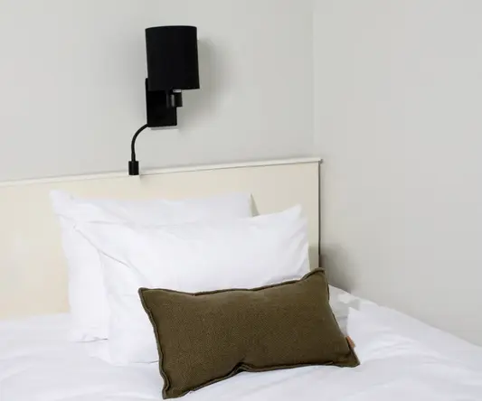 a bed with pillows and a lamp