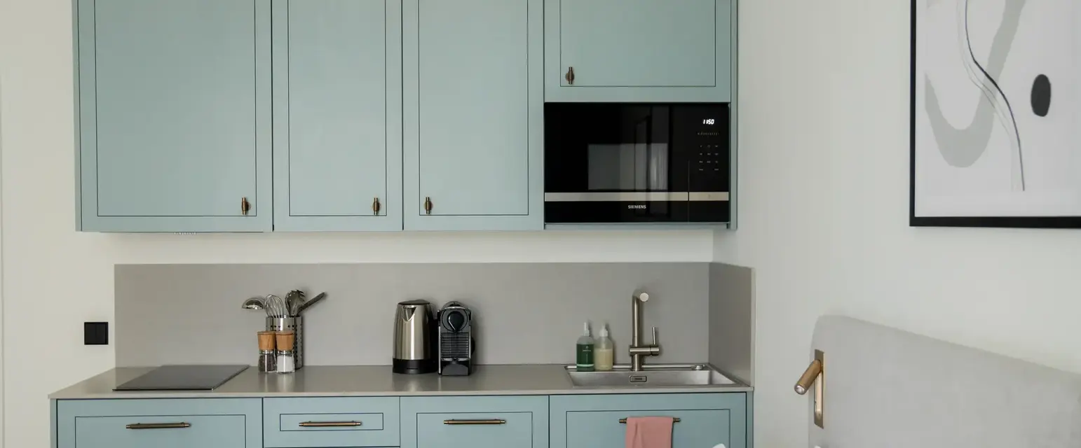a kitchen with blue cabinets and a bed