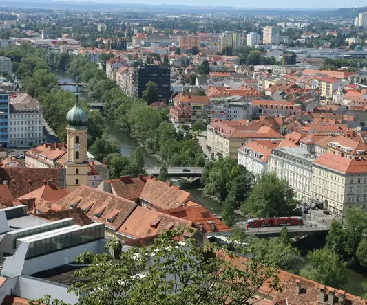 a city with red roofs and a river