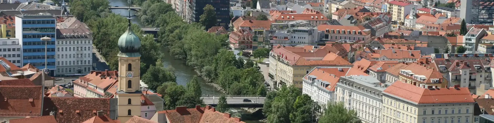 a city with red roofs and a river