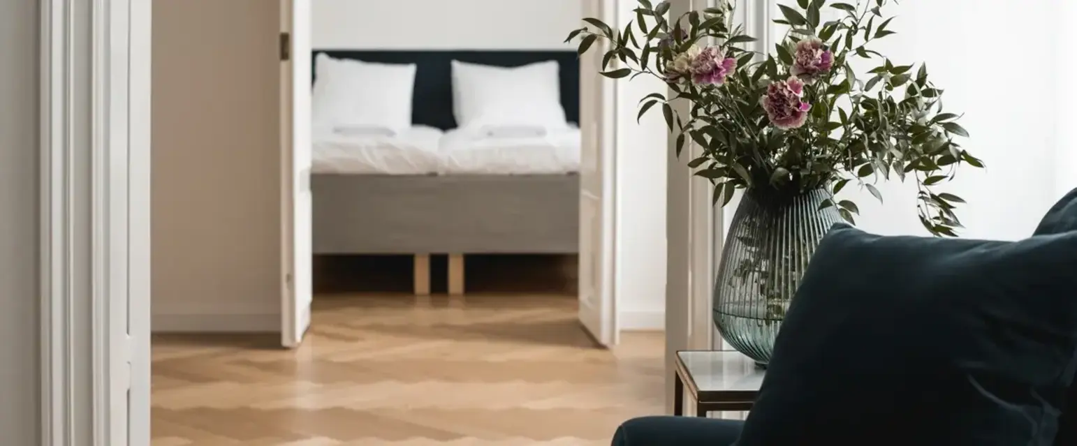 a vase of flowers in front of a bed