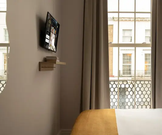 a bed in a room with a tv on the wall
