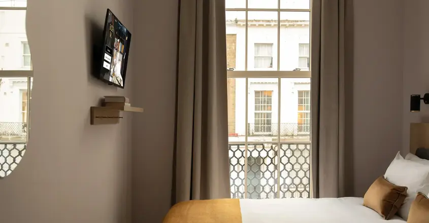a bed in a room with a tv on the wall