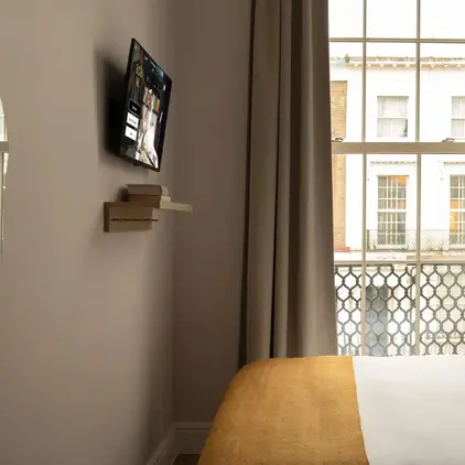 a bed in a room with a tv on the wall