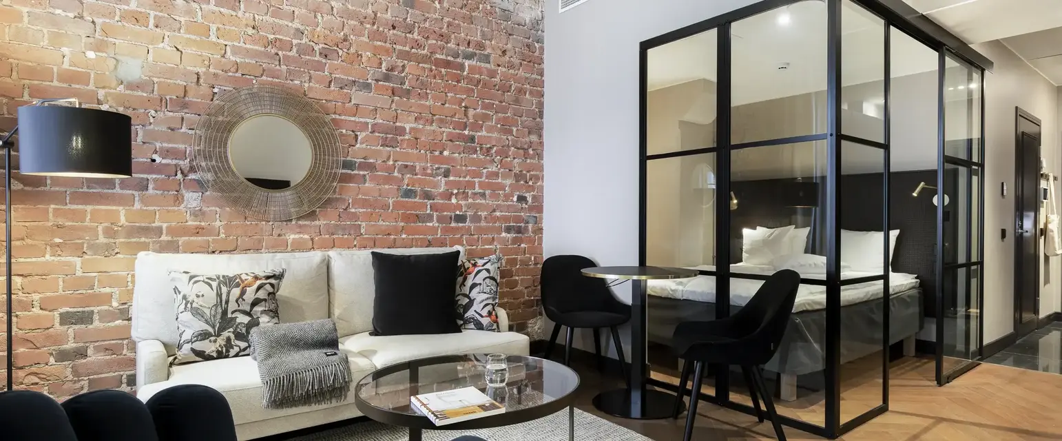 a room with a brick wall and a couch and a glass cabinet