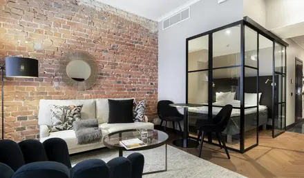 a room with a brick wall and a couch and a glass cabinet