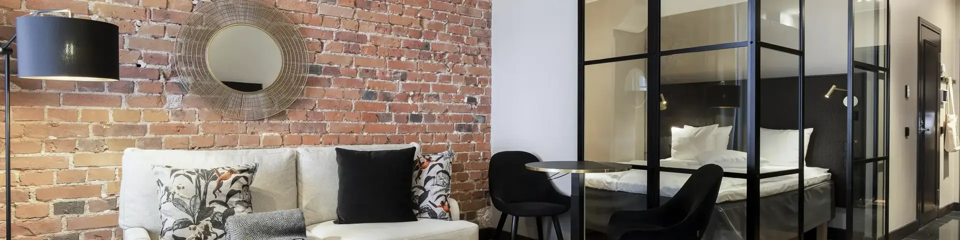 a room with a brick wall and a couch and a glass cabinet