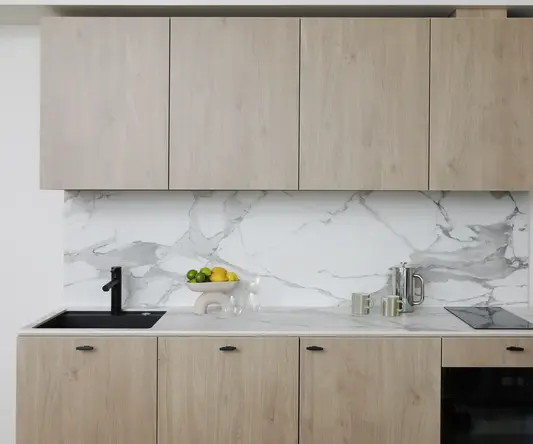 a kitchen with wood cabinets and marble counter tops