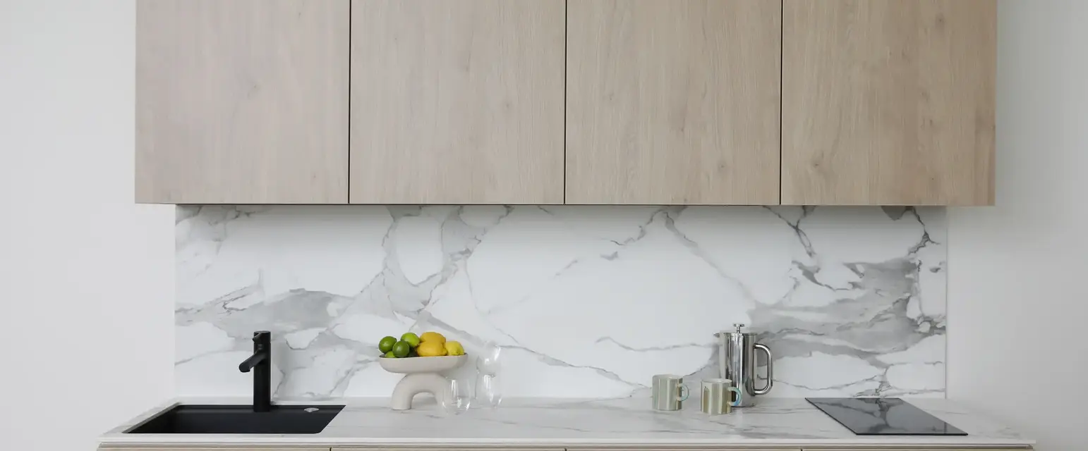 a kitchen with wood cabinets and marble counter tops