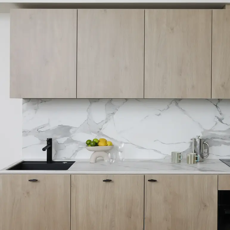 a kitchen with wood cabinets and marble counter tops