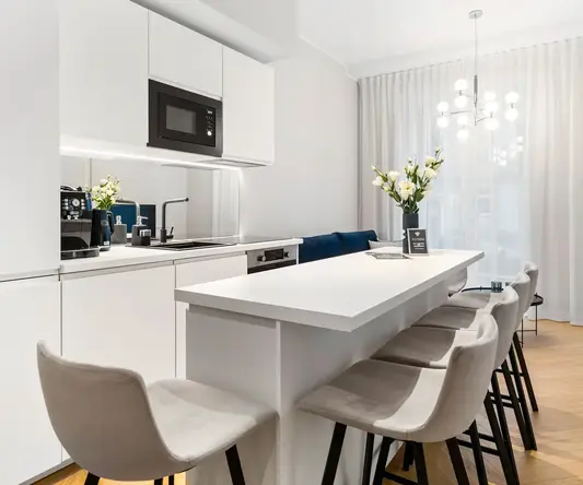 a kitchen with white cabinets and white countertops