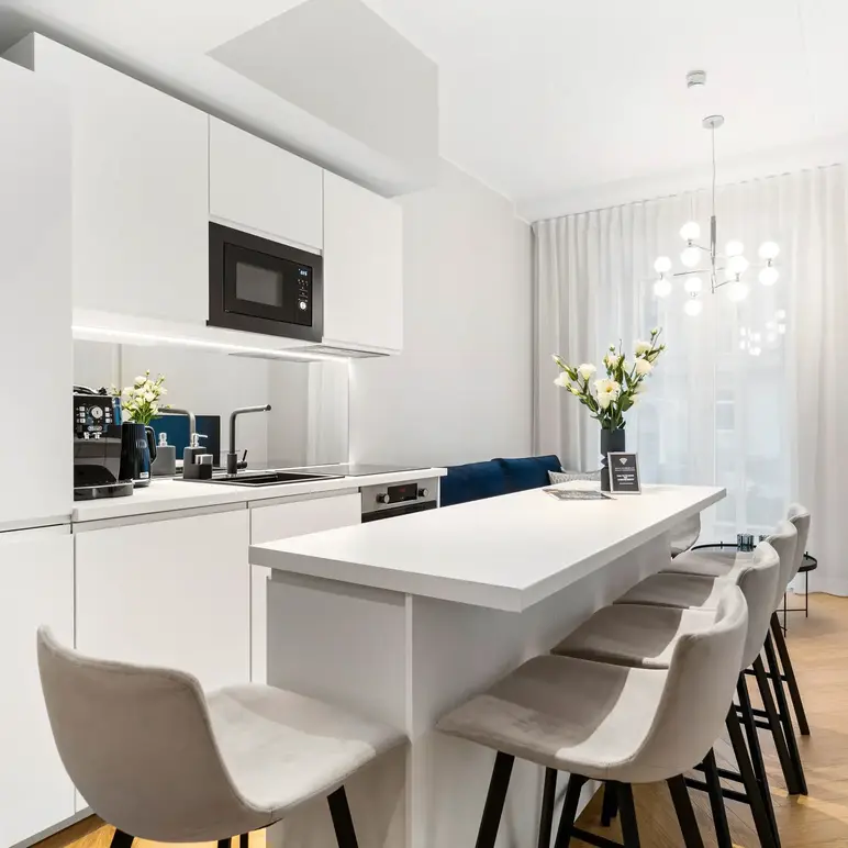a kitchen with white cabinets and white countertops