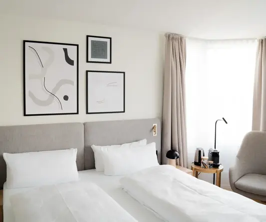 a bed with white sheets and pillows