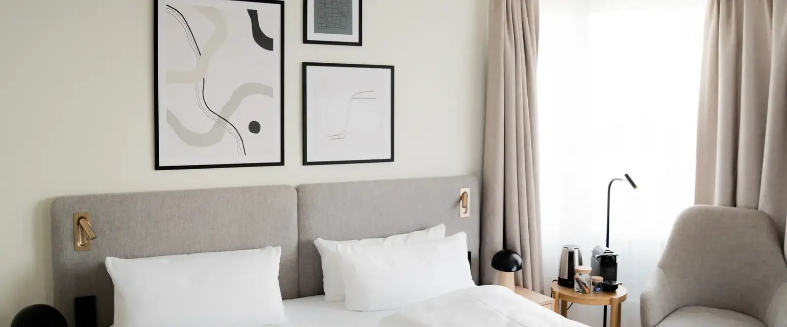 a bed with white sheets and pillows