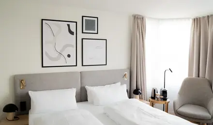 a bed with white sheets and pillows