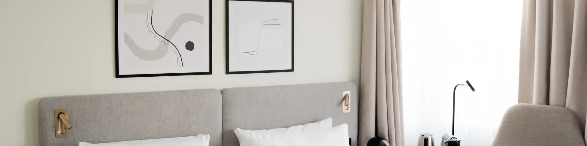a bed with white sheets and pillows