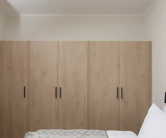 a bedroom with wooden cabinets
