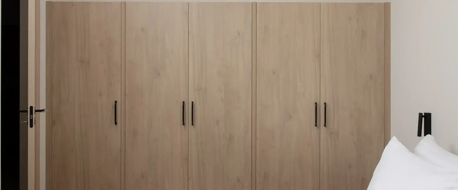 a bedroom with wooden cabinets