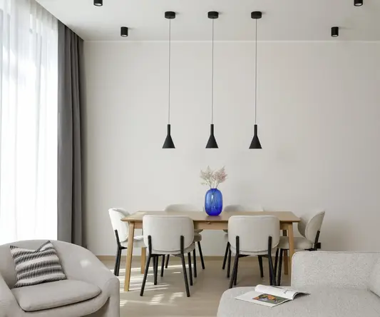 a dining table with chairs and a blue vase