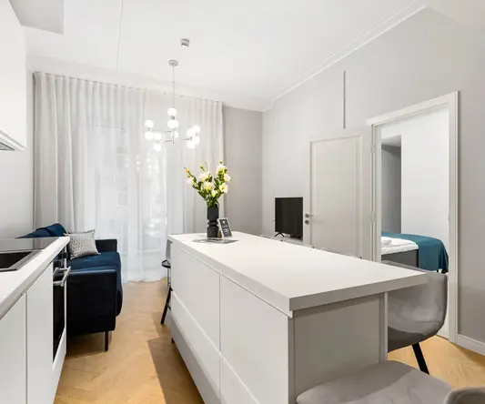 a white kitchen with a table and chairs