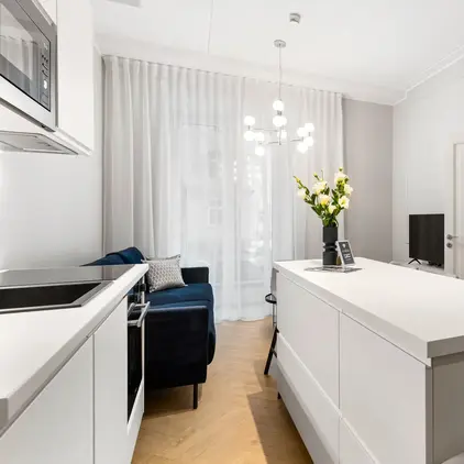 a white kitchen with a table and chairs