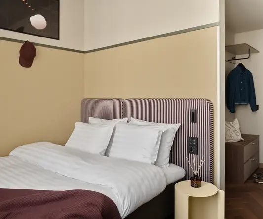 a bed with a striped headboard and a small table